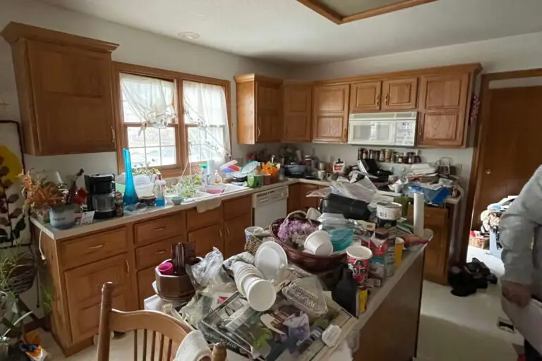 A Cluttered Kitchen In An Older House, Counters Covered In Dishes, Papers And Belongings